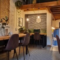 Cosy interior of Ginger Tree Coffee with patterned feature wall, pendant lights and plants